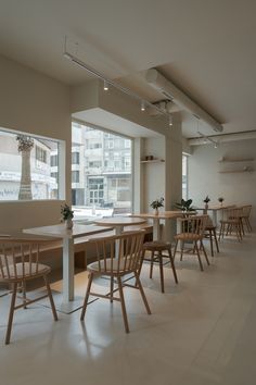 an empty restaurant with wooden chairs and tables