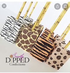 four zebra print candles are lined up in a row with bamboo sticks sticking out of them