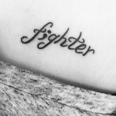 a tattoo with the word fighter written on it's left arm and in cursive font