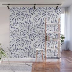 a living room with white walls and wooden flooring next to a plant on a shelf