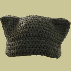 a gray crocheted pillow on a beige background