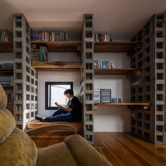 a man is sitting on the window sill reading