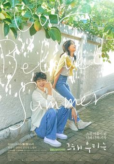 two people sitting next to each other on the ground under a tree with writing all over it