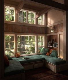 a living room filled with lots of windows next to a green couch and coffee table