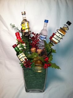 an arrangement of liquor bottles in a glass vase