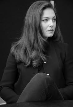 a black and white photo of a woman sitting down