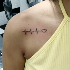 a woman with a heartbeat tattoo on her shoulder