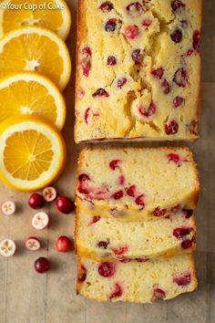 slices of orange cranberry bread next to sliced oranges and cranberries