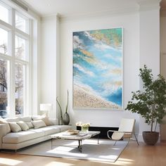 a living room filled with furniture and a large painting hanging on the wall above it