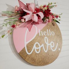 a wooden sign that says hello love hanging on the wall next to a candle and flowers