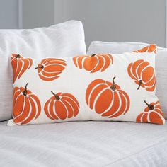 an orange pumpkin pillow on a white couch