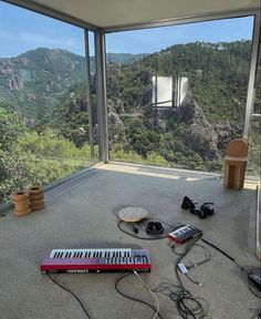 there is a keyboard and other electronic equipment on the floor in front of a large window