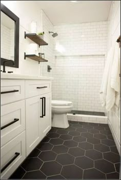 a bathroom with black and white flooring and hexagonal tiles on the walls