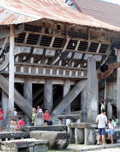 people are standing in front of an old wooden structure