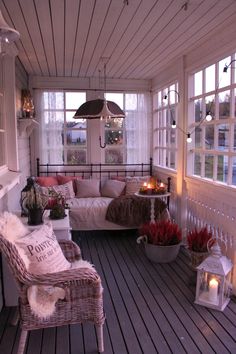 the porch is decorated with wicker furniture and candles