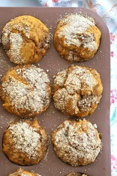 a tray filled with muffins covered in powdered sugar