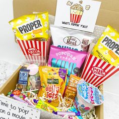 the popcorn box is filled with snacks, candy and movie tickets to give as a birthday gift