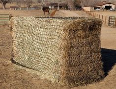 a large hay bale sitting on top of a dry grass field