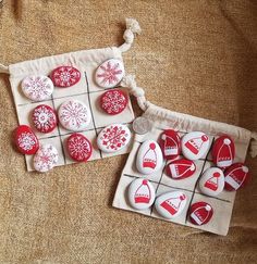 two bags filled with red and white buttons sitting on top of a brown cloth bag