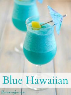 two blue hawaiian cocktails on a table with text overlay that reads, blue hawaiian