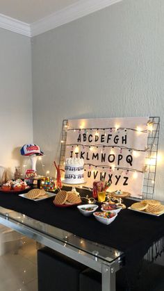 a table that has some food on it and lights in the background with words above it