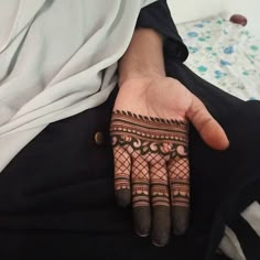 a woman's hand with henna tattoos on it