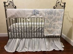 a baby crib with two blankets and a monogrammed blanket