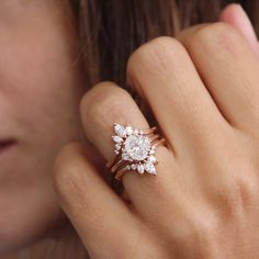 a close up of a person's hand with a diamond ring on their finger