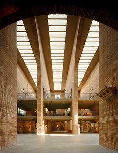 the inside of a large building with high ceilings and columns on both sides, leading to an atrium