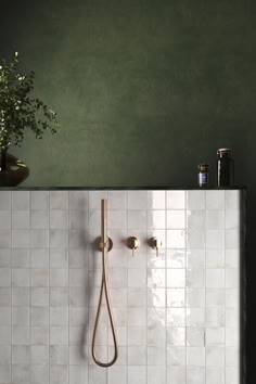 a white tiled bathroom with a shower head and hand held shower faucet in the corner