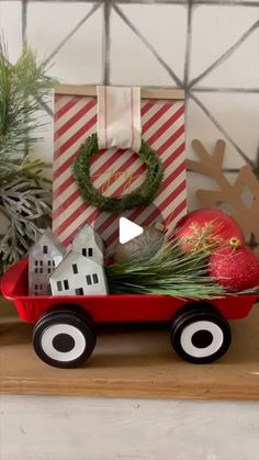 a red wagon filled with christmas decorations on top of a shelf