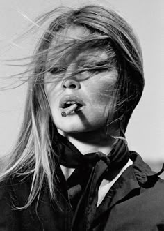 a black and white photo of a woman with her hair blowing in the wind on display