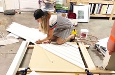 a woman is working on an unfinished piece of wood