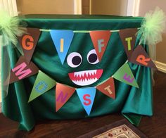 a green chair covered in paper cutouts and decorated with letters that spell out g is for monster