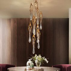 a dining room table with chairs and a chandelier hanging from it's ceiling