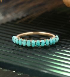 a gold ring with turquoise stones on it