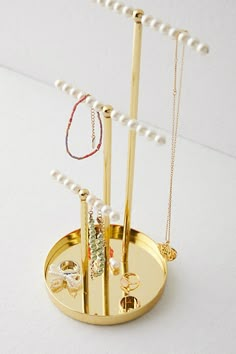 a gold jewelry holder with pearls and necklaces