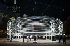 people standing in front of a circular structure at night