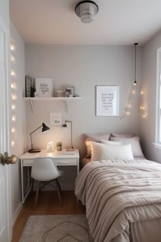 a bedroom with a bed, desk and lights on the wall above it's headboard