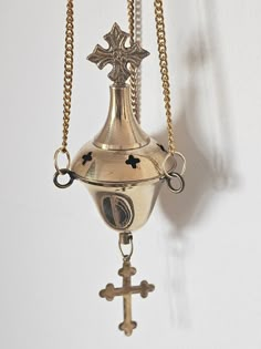 a small bell with a cross hanging from it's side