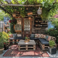 an outdoor living area with couches, tables and potted plants on the ground