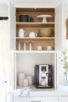 a coffee maker is sitting on top of a cabinet in the corner of a kitchen