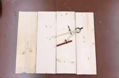 a pair of scissors is sitting on some wood planks and are being used to make a piece of art