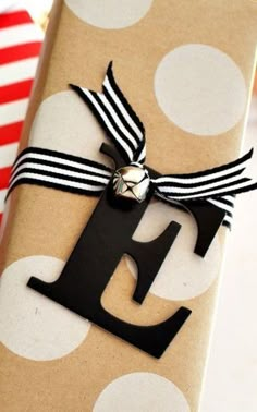 a gift wrapped in brown paper with a black and white ribbon tied around the letter e