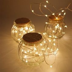 three glass jars filled with cookies and lights