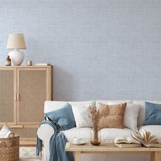 a white couch sitting next to a wooden table in a living room under a blue wall