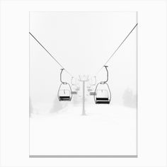 two ski lifts in the snow on a foggy day