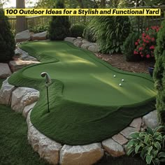 a small golf course in the middle of a garden with rocks and plants around it