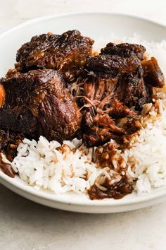 a white plate topped with meat and rice