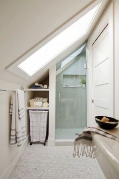 an attic bathroom with skylights and white walls